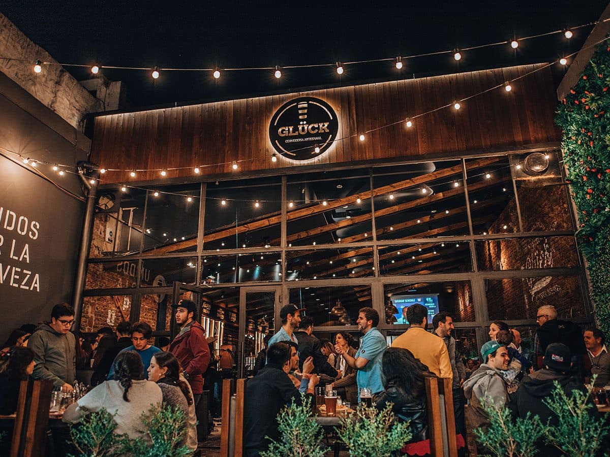 Terraza de la cervecería Glück en Palermo, Buenos Aires, llena de gente brindando
