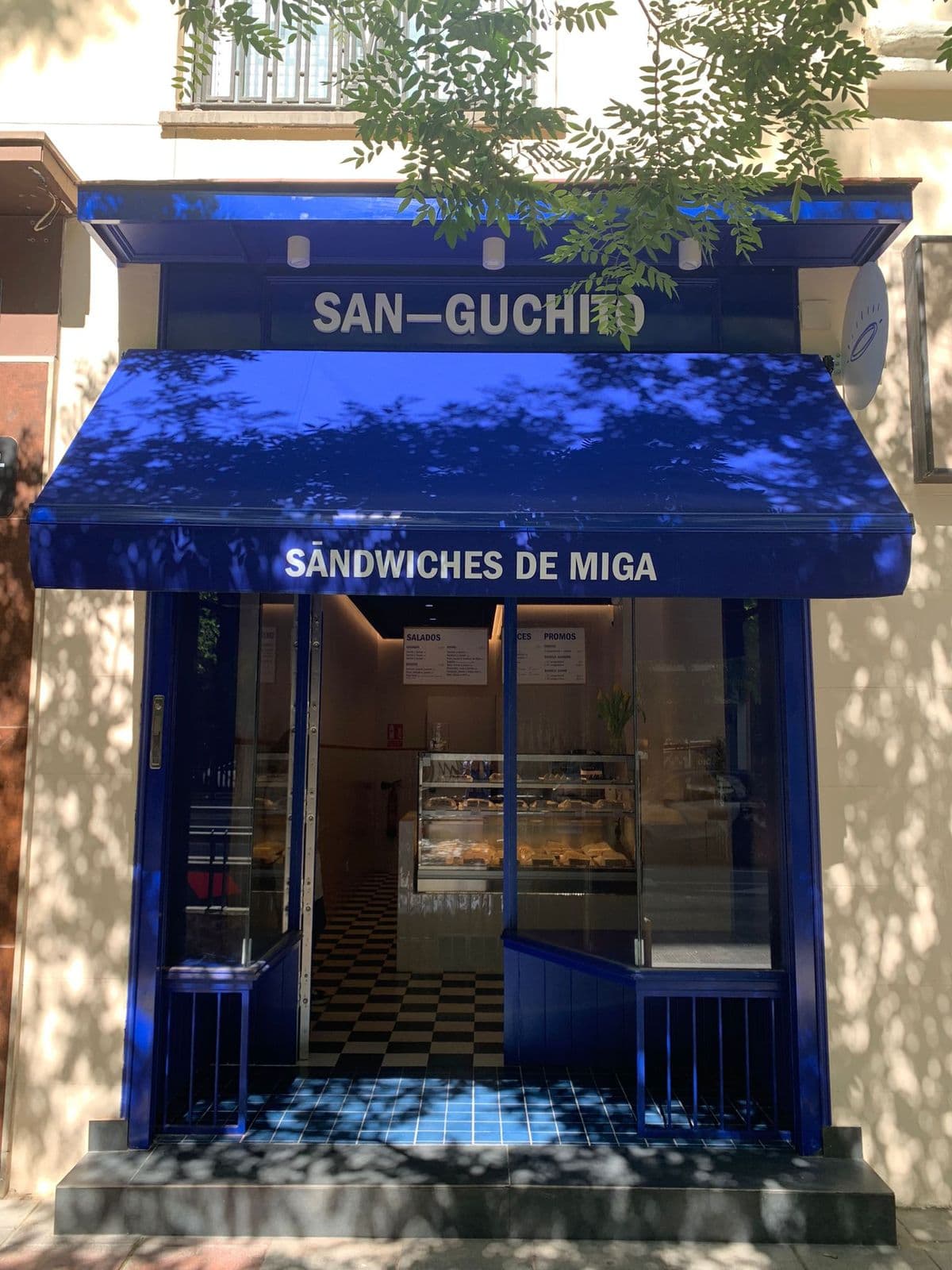 Fachada azul de San-Guchito, sándwiches de miga, en Madrid