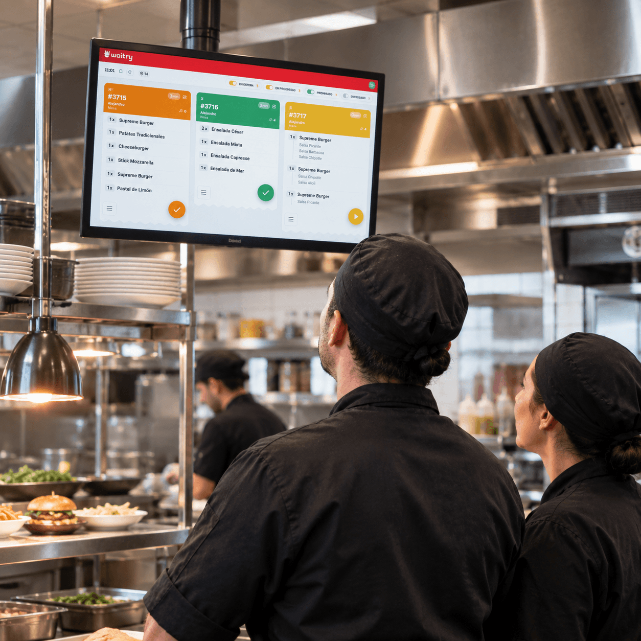 Cocineros mirando la pantalla de cocina de Waitry con los pedidos por estado