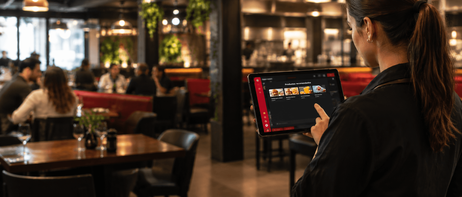 Camarera toma pedidos en el sistema de punto de venta desde una tablet en sala