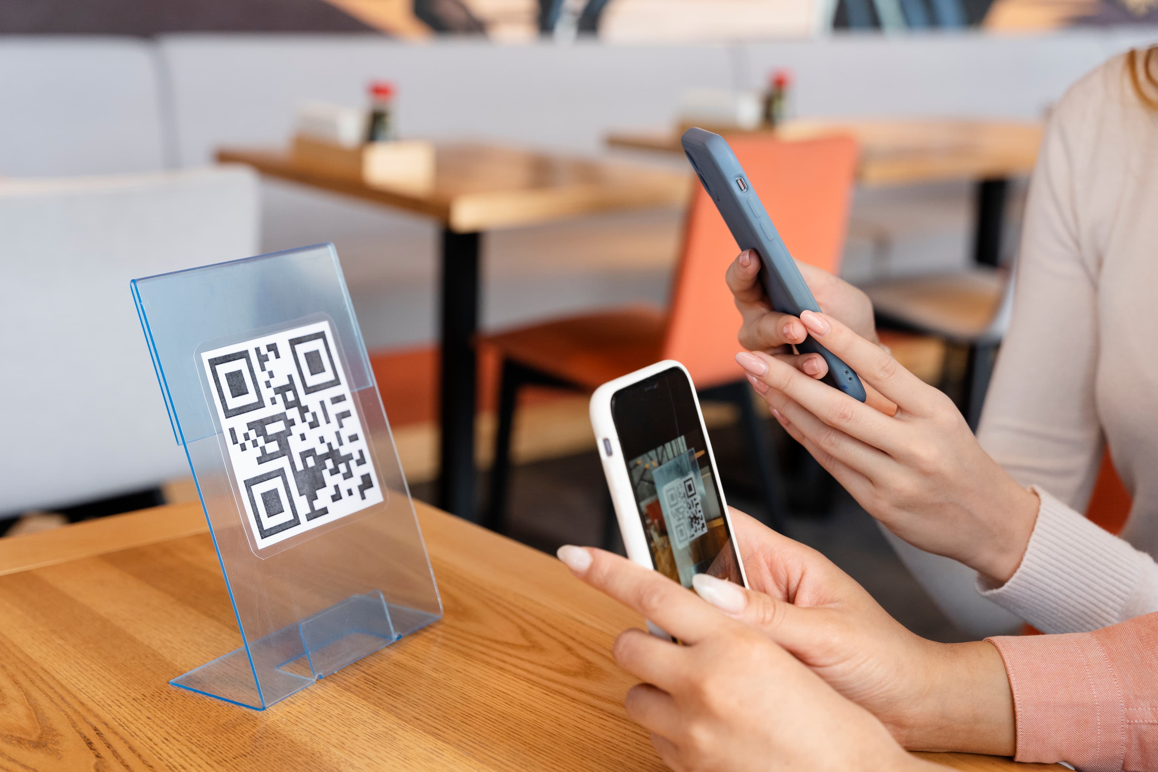 Amigos piden desde la mesa escaneando el código QR con el teléfono, sin descargar apps